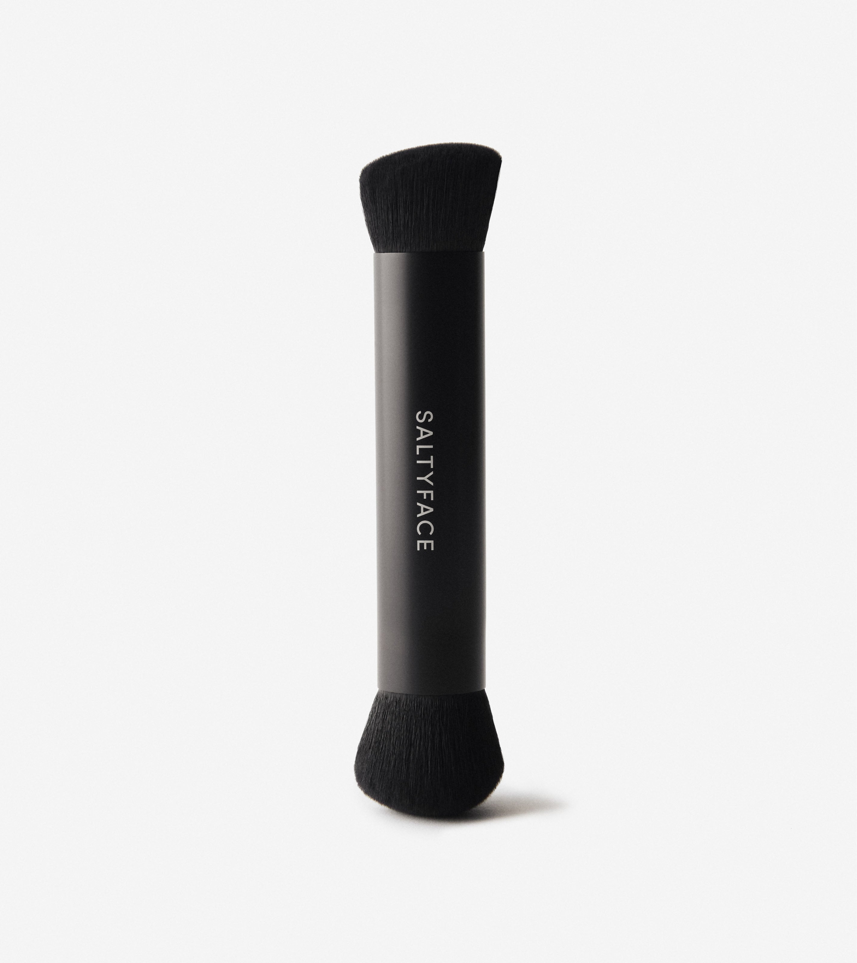 Black, dual-sided makeup brush featuring the Saltyface logo in the middle.