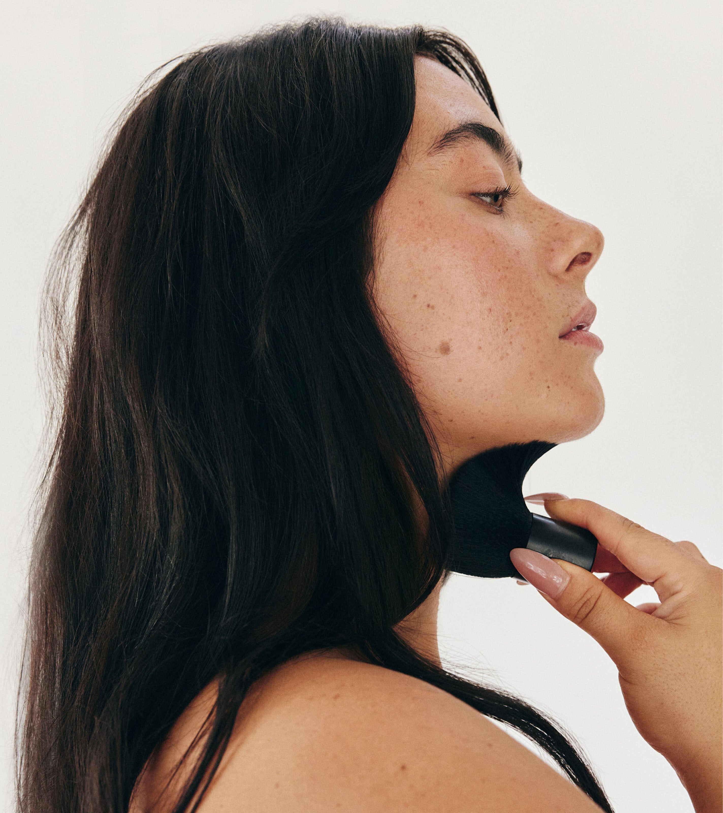 Model using Saltyface Brush No. 1 to apply Tanning Water on her neck. 
